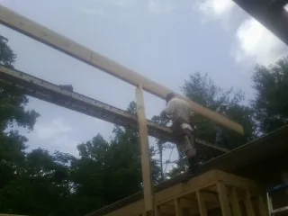 Carpenter setting a ridge beam over a new addition frame — Ice Dam Removal by Roofing Brothers in Warrington