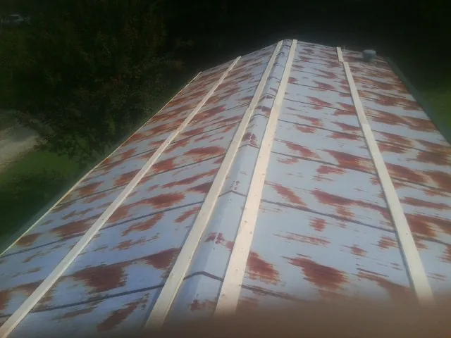 Rusted metal roof panels with new wood purlins before replacement — Storm Damage Roof Repair in Warrington by Roofing Brothers