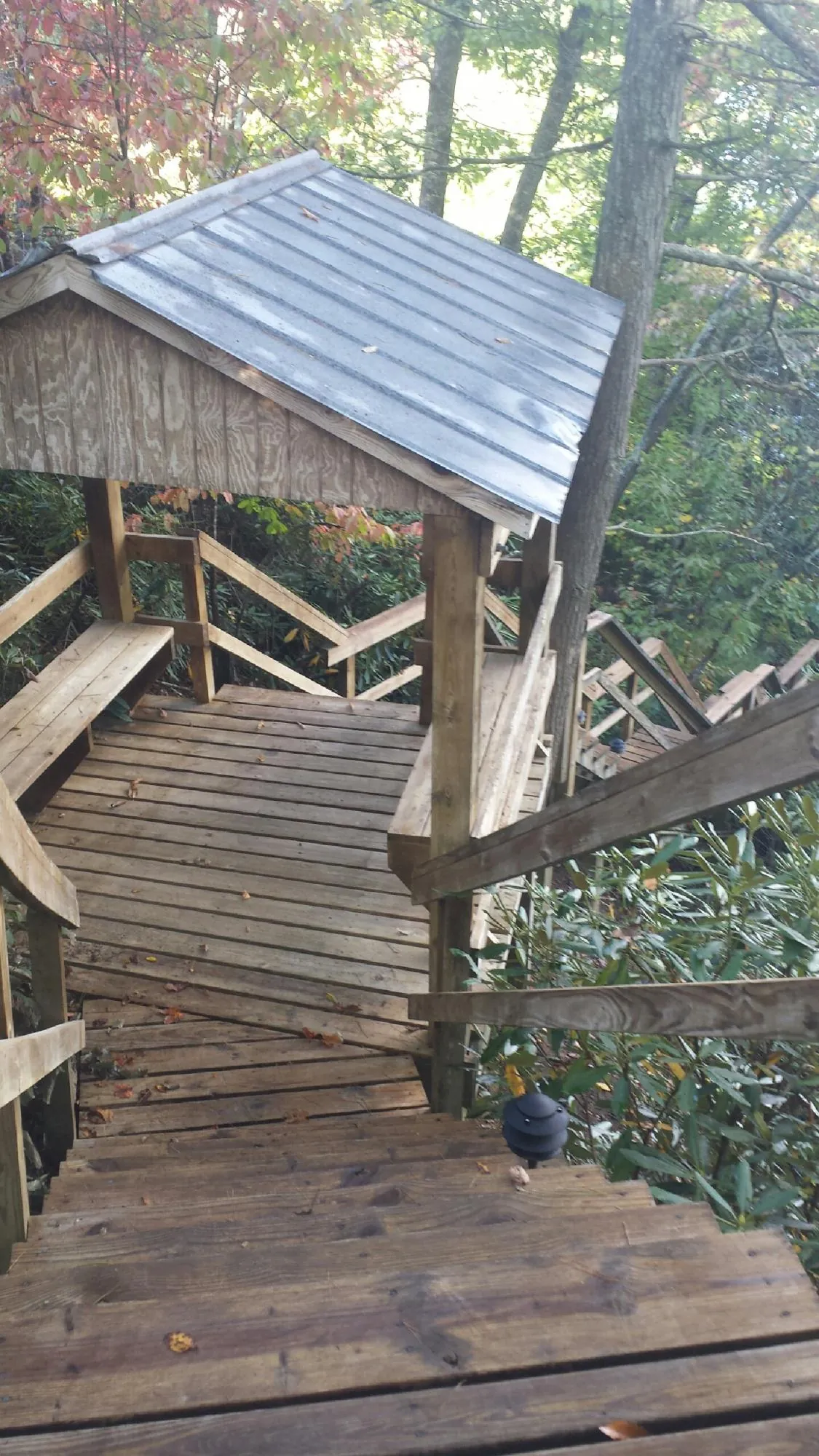 Metal roofed shelter over wooden steps on a wooded walkway — Skylight Repair & Installation work by our crew in Warrington