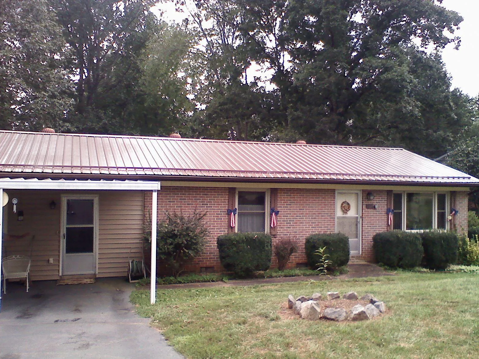 Bronze metal roof and carport on a brick ranch home — Roof Repair work by our crew in Warrington